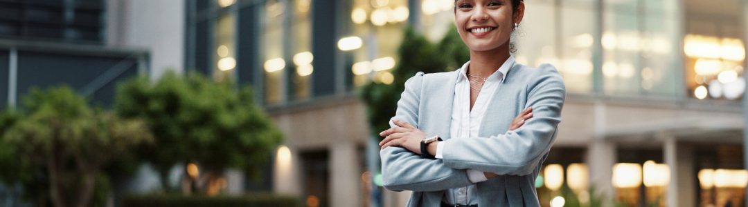 Businesswoman, arms crossed or portrait by office building in city for career, smile for accounting.
